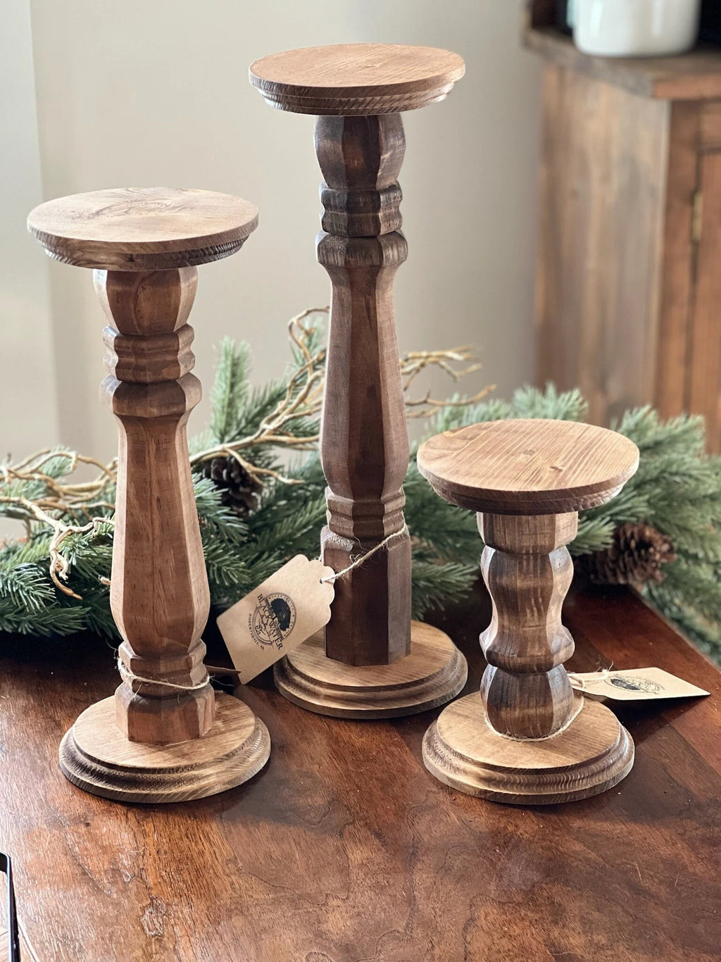 Set of 3 wooden candle pillars in rustic farmhouse style with natural stain finish

Close-up of wooden candle pillars with pillar candles, sizes 7.5", 13", and 15.5"

Rustic wooden candle holders perfect for farmhouse home décor and weddings

Handcrafted wooden candle pillars on wooden table with greenery background