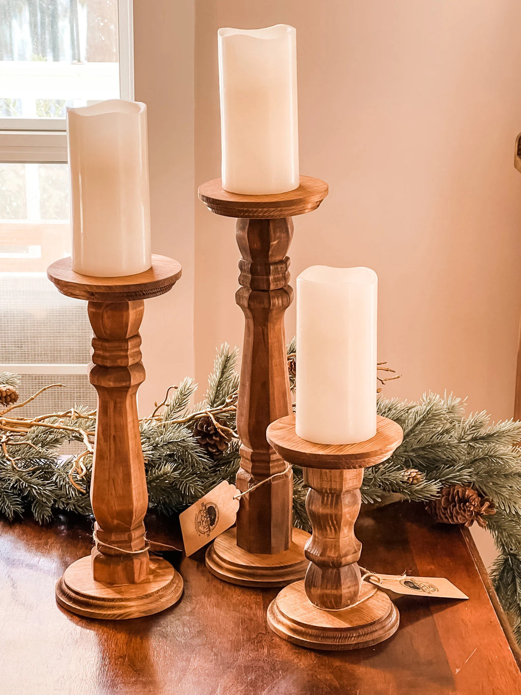 Set of 3 wooden candle pillars in rustic farmhouse style with natural stain finish

Close-up of wooden candle pillars with pillar candles, sizes 7.5", 13", and 15.5"

Rustic wooden candle holders perfect for farmhouse home décor and weddings

Handcrafted wooden candle pillars on wooden table with greenery background