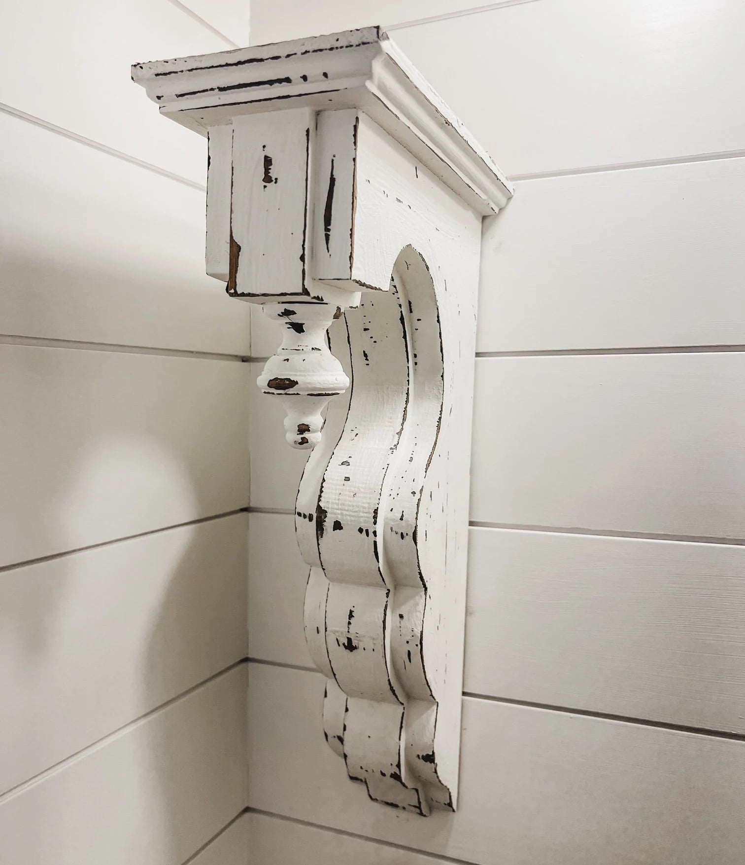White distressed wood corbel with finial side view

Pair of white distressed corbels with finials on rustic wooden surface

Close-up of carved finial detail on white distressed corbel

17-3/8 inch tall white distressed wood corbels for mantel support